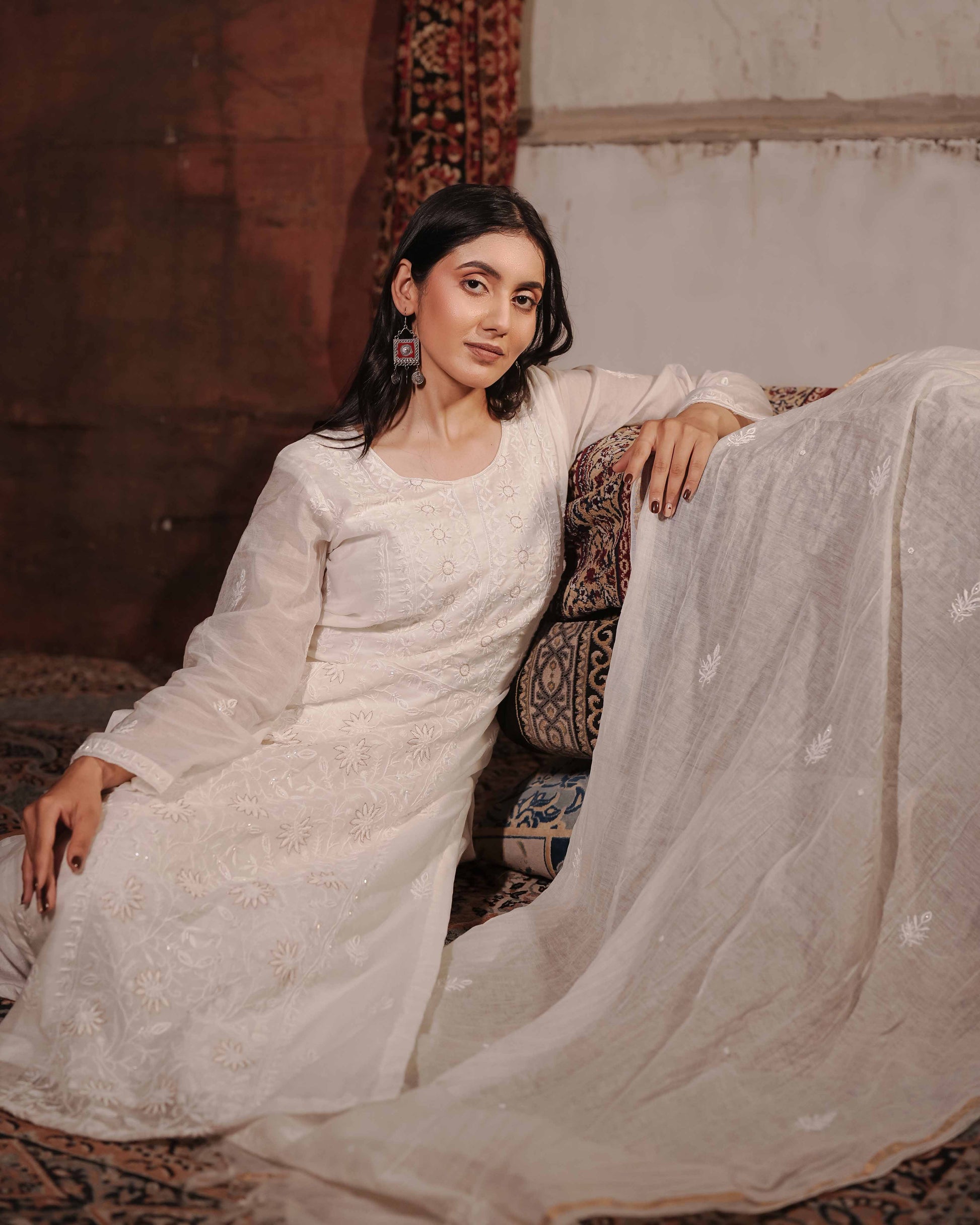Sophisticated white Mul Chanderi suit detailed with traditional Lucknowi chikankari patterns.
High-quality ethnic evening wear from Art of Awadh, ideal for your next special occasion.
