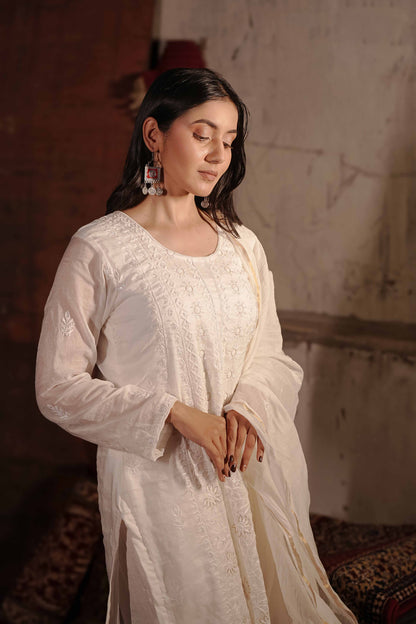 Luxurious white Mul Chanderi suit featuring intricate Lucknowi chikankari embroidery.
The perfect graceful ensemble for evening parties and sophisticated traditional events.
