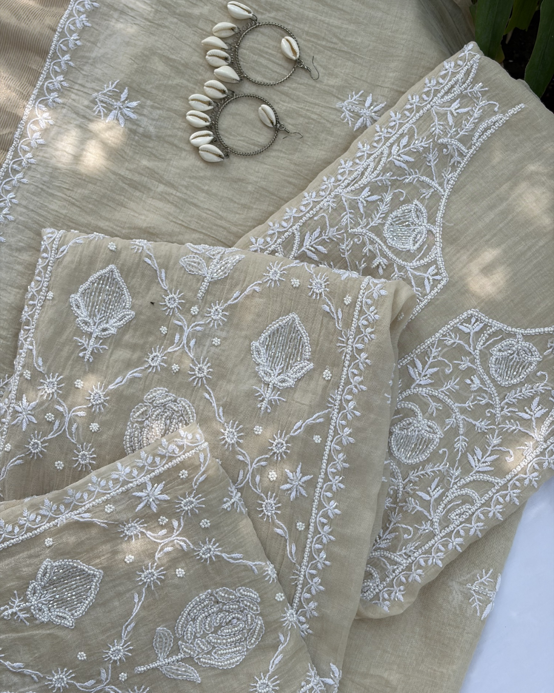 Intricate Lucknowi chikankari art of awadh displayed on a beige mul chanderi garment.