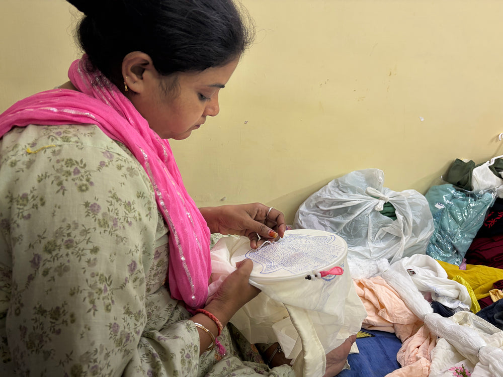 An artisan carefully tracing delicate, intricate floral patterns onto fabric for Art of Awadh chikankari work.